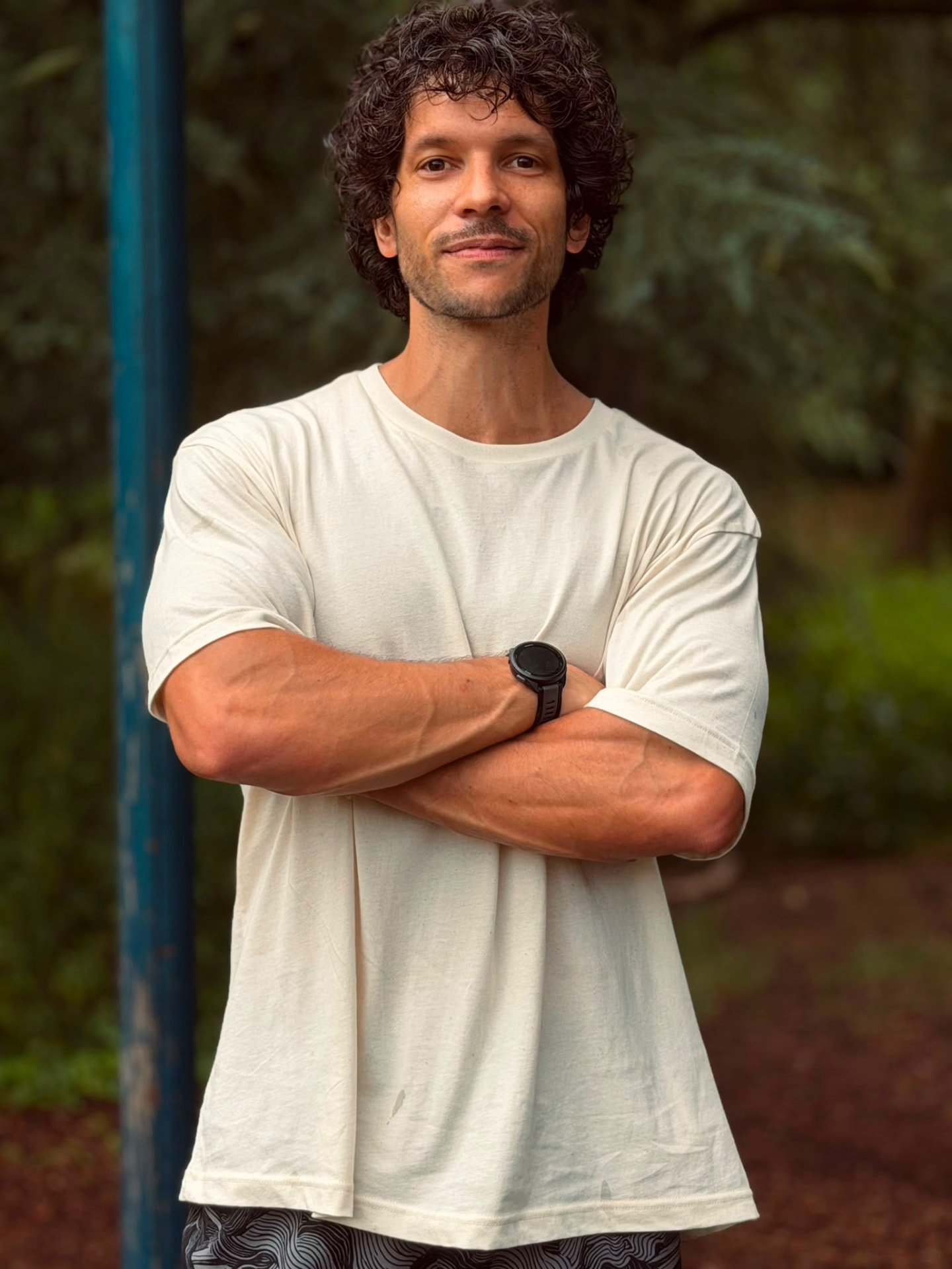 Portrait d'Axel, coach sportif, bras croisés dans un parc